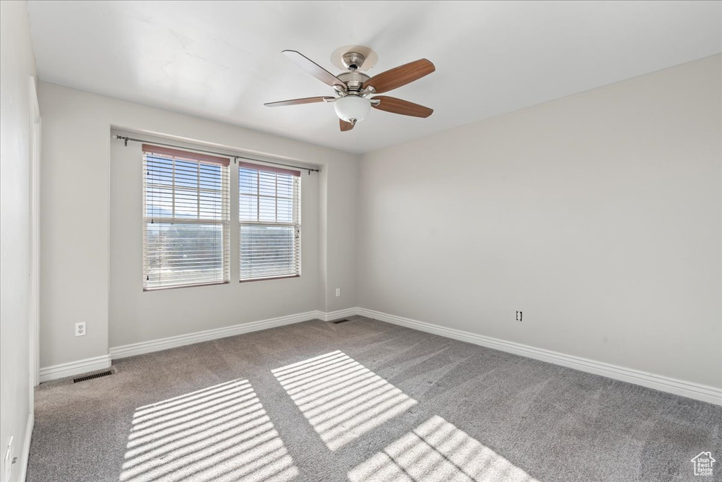 Unfurnished room featuring light colored carpet and ceiling fan