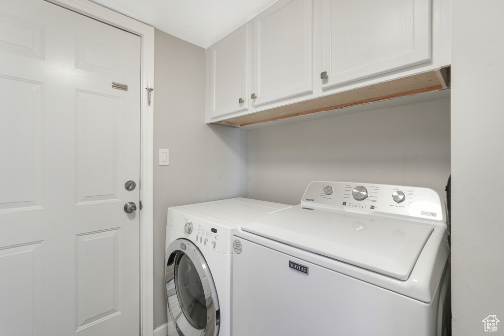 Laundry room featuring cabinets and separate washer and dryer