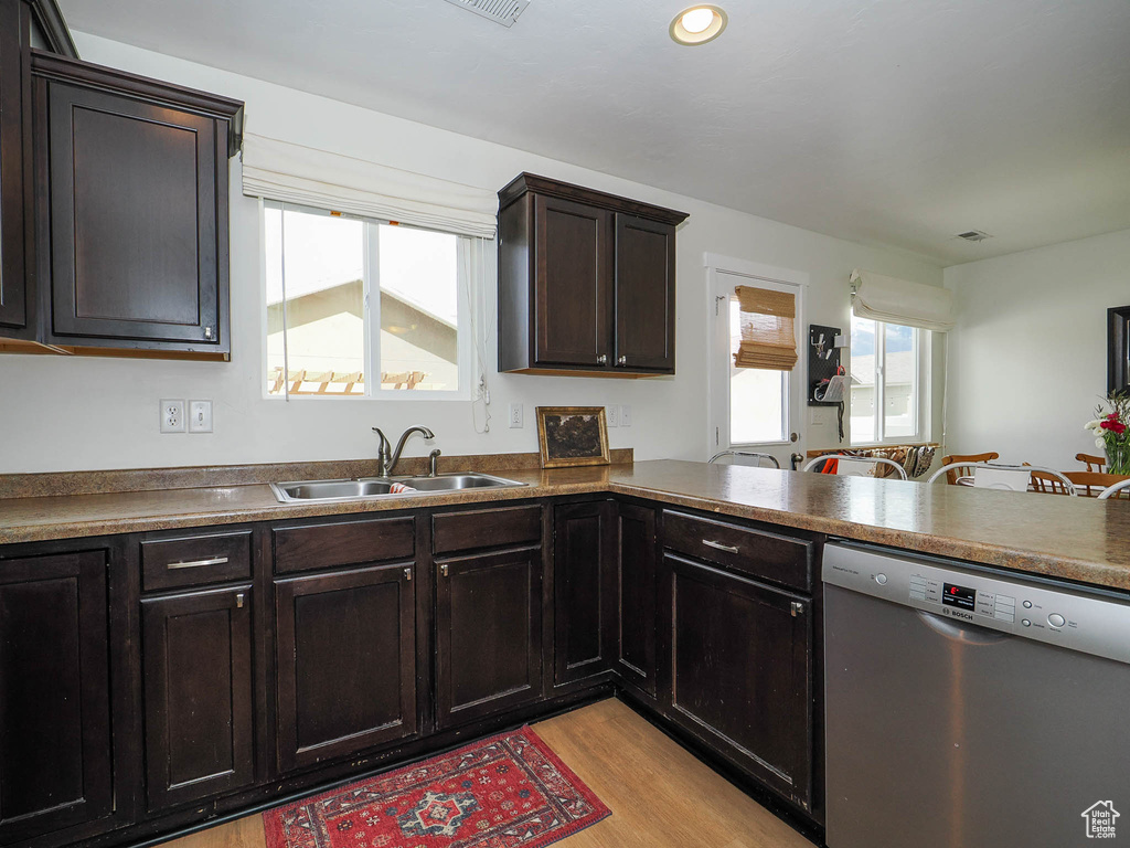 Kitchen featuring sink, light hardwood / wood-style flooring, dark brown cabinetry, and stainless steel dishwasher