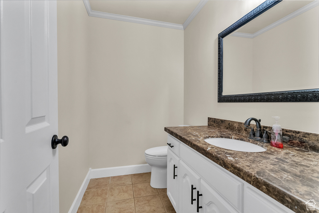 Bathroom featuring crown molding, tile flooring, toilet, and vanity