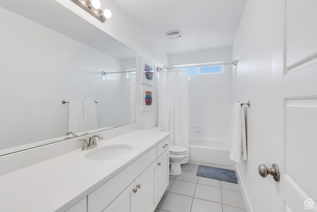 Full bathroom with toilet, shower / tub combo, tile floors, and large vanity