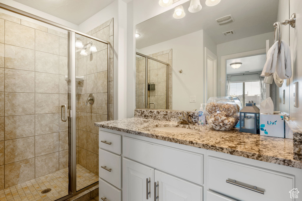 Bathroom with walk in shower and vanity with extensive cabinet space