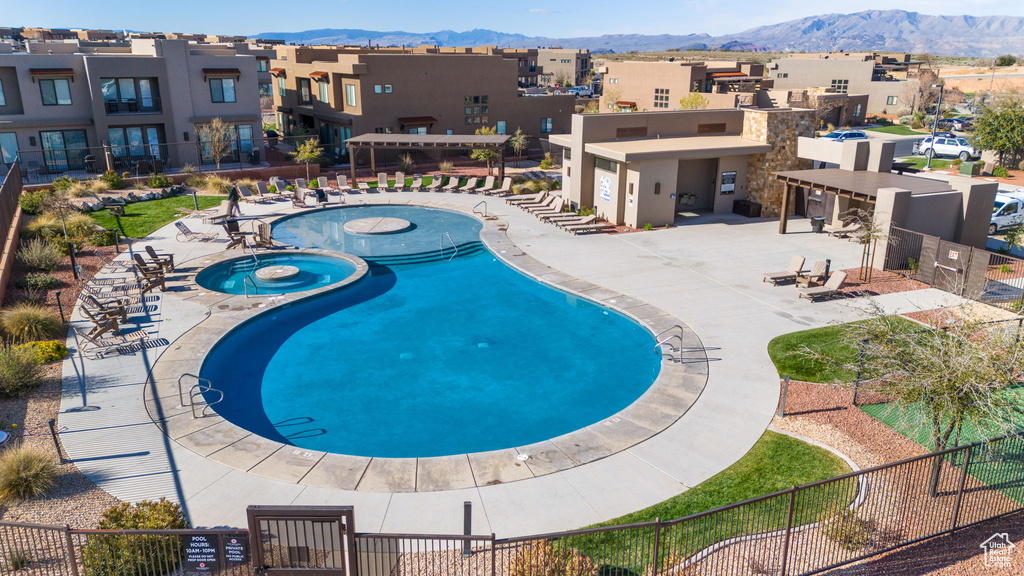 View of swimming pool featuring a mountain view, a community hot tub, and a patio