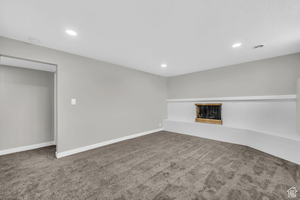 Unfurnished living room featuring dark colored carpet