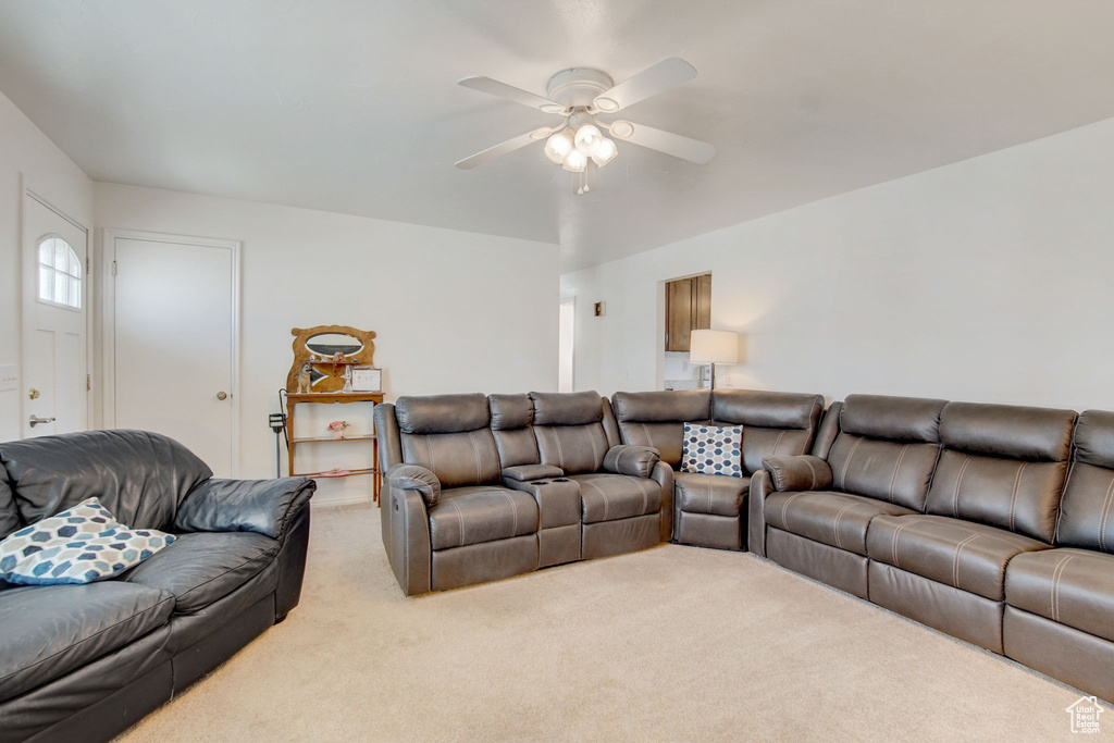 Living room featuring ceiling fan and light carpet