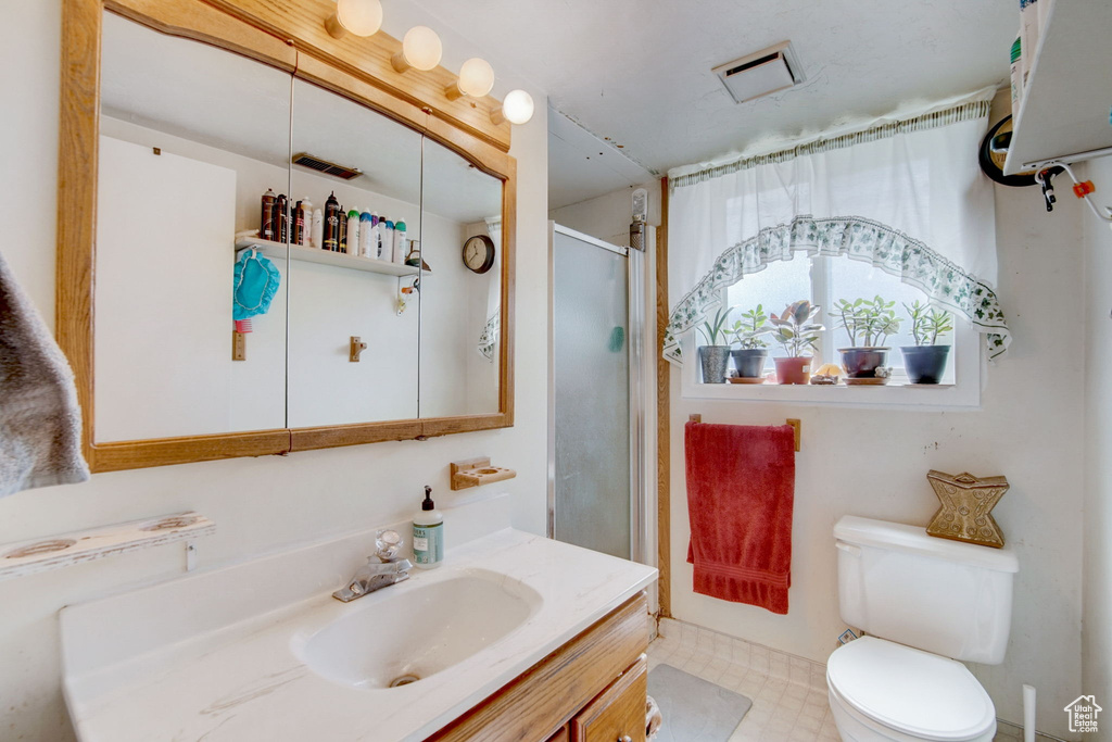 Bathroom featuring tile flooring, large vanity, and toilet