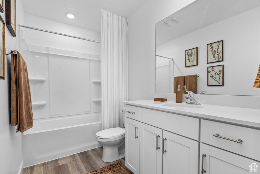 Full bathroom with hardwood / wood-style floors, bathing tub / shower combination, toilet, and vanity