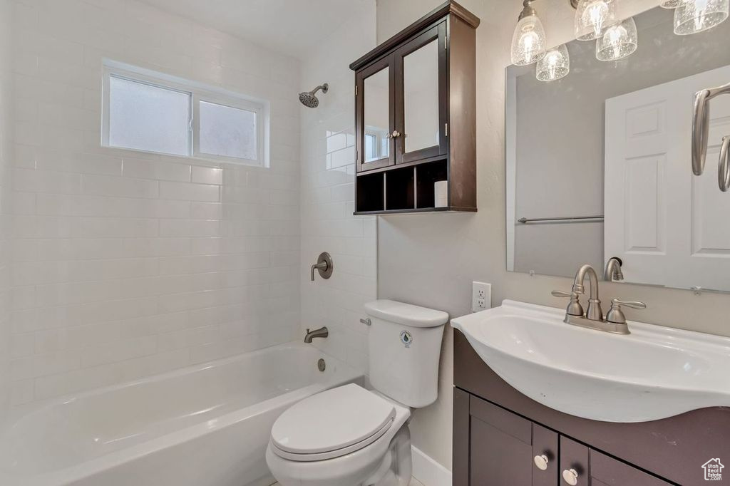 Full bathroom featuring toilet, vanity, and tiled shower / bath combo