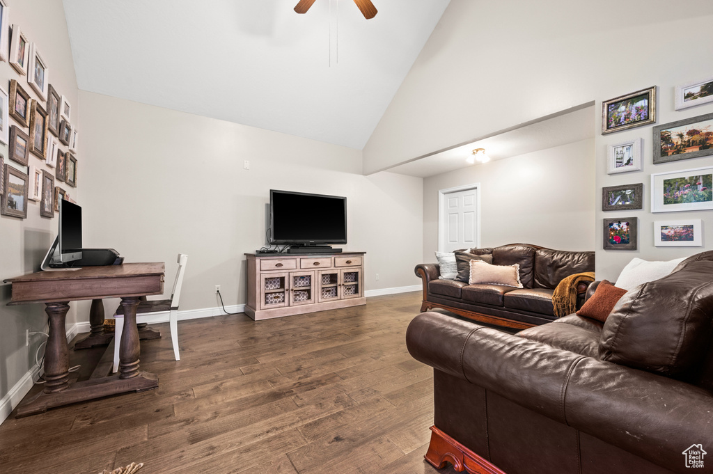 Living room featuring high vaulted ceiling, dark hardwood / wood-style flooring, and ceiling fan