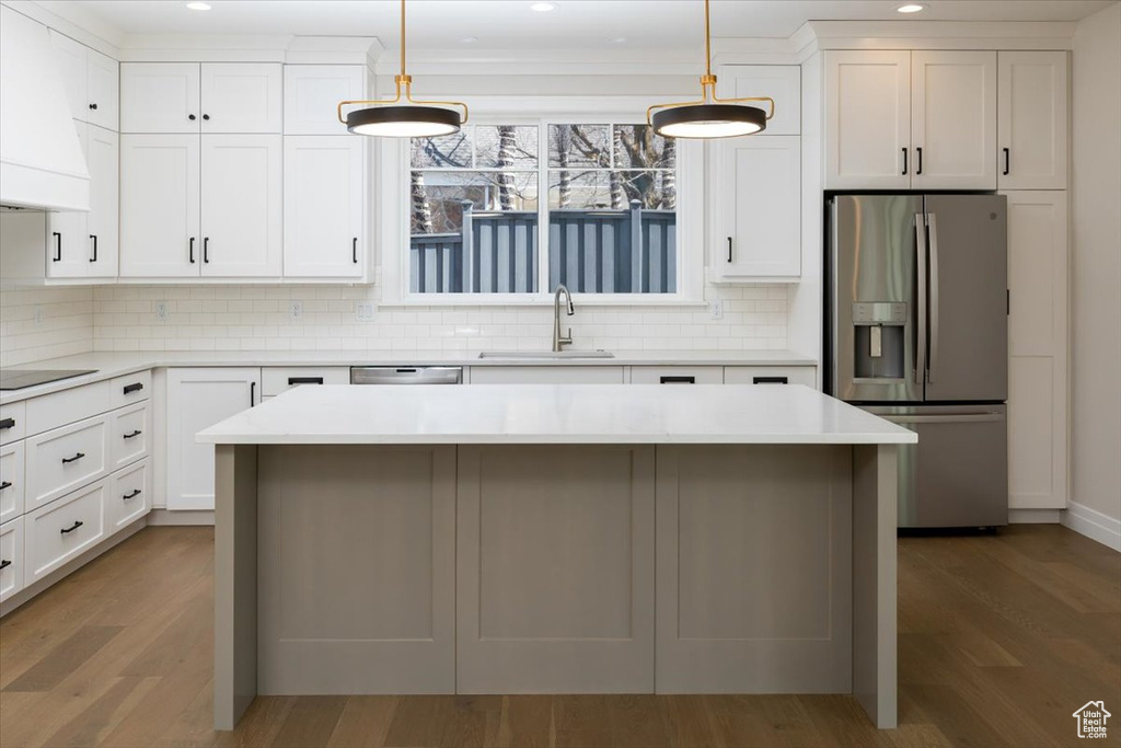Kitchen with appliances with stainless steel finishes, sink, light hardwood / wood-style floors, and custom range hood