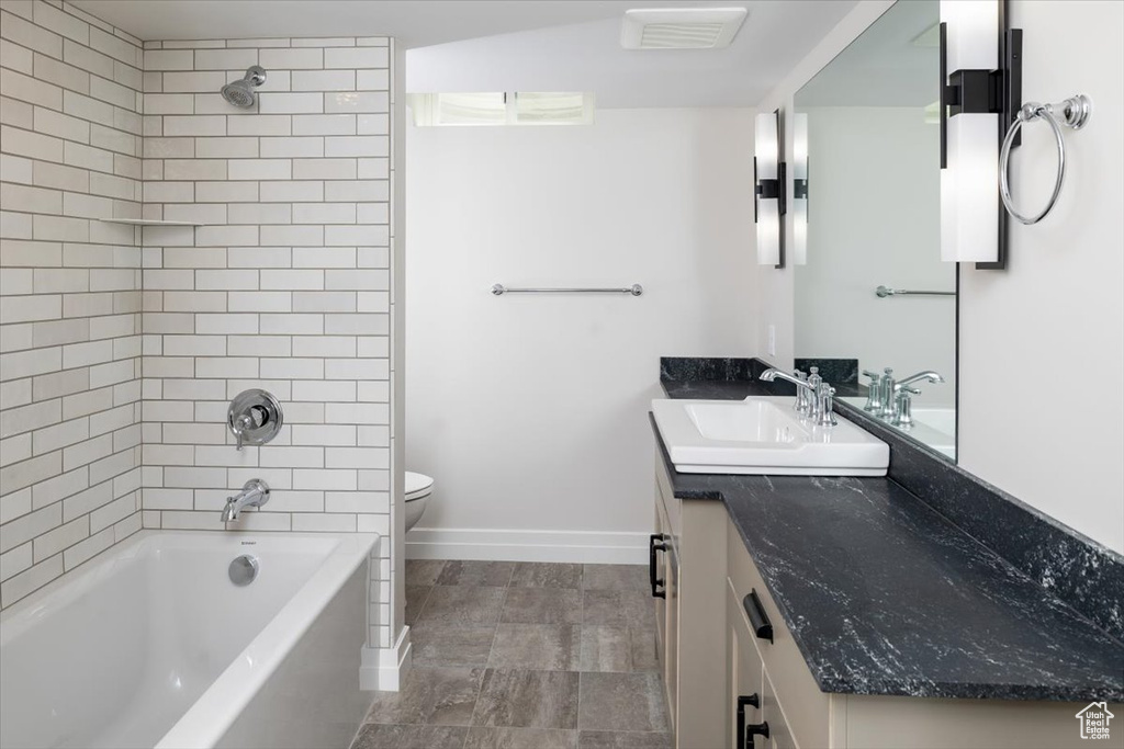 Full bathroom featuring tile flooring, tiled shower / bath combo, toilet, and vanity
