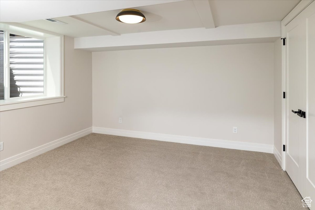 Carpeted empty room with beam ceiling