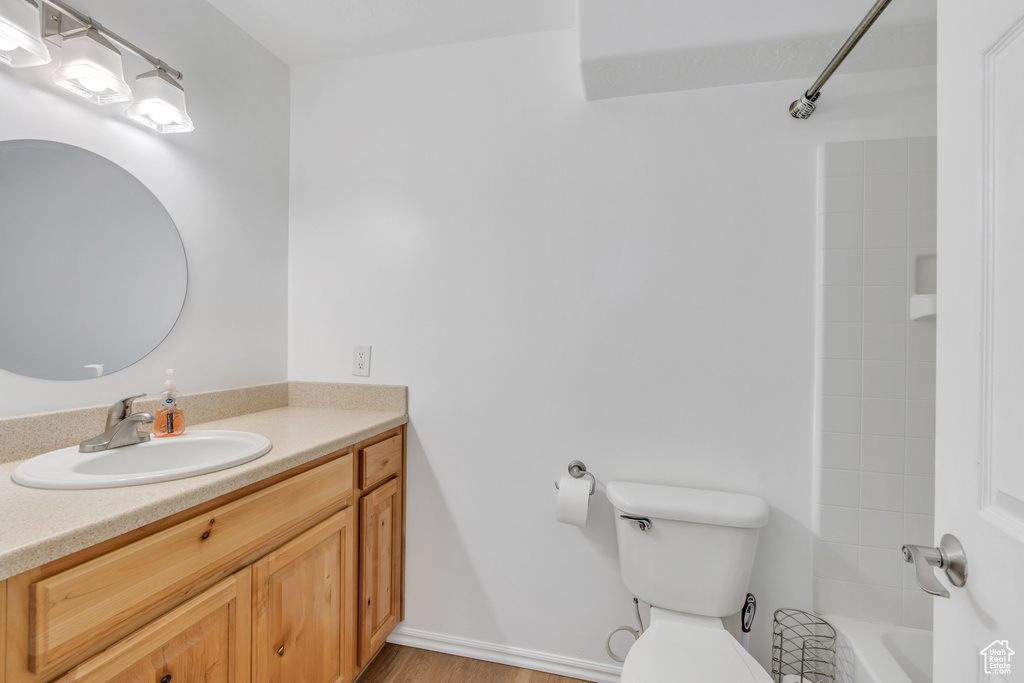 Full bathroom featuring toilet, bathtub / shower combination, vanity, and wood-type flooring