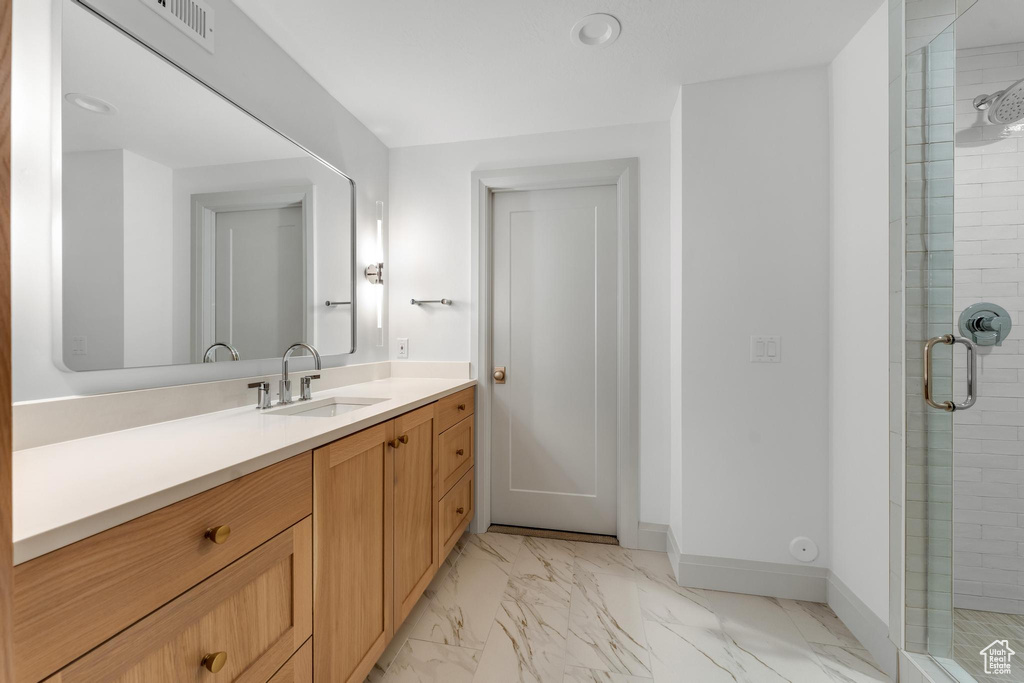 Bathroom featuring tile flooring, walk in shower, and oversized vanity