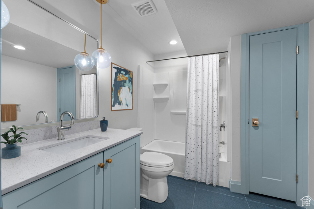 Full bathroom featuring vanity with extensive cabinet space, tile flooring, toilet, and shower / tub combo with curtain