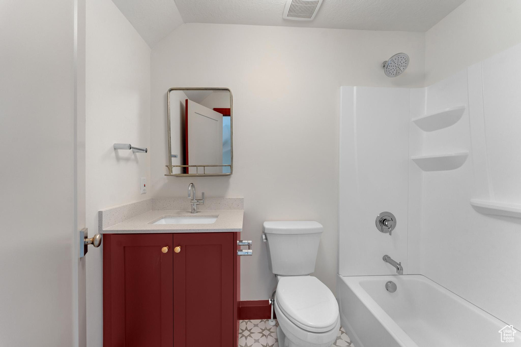 Full bathroom featuring  shower combination, toilet, vanity, a textured ceiling, and tile floors
