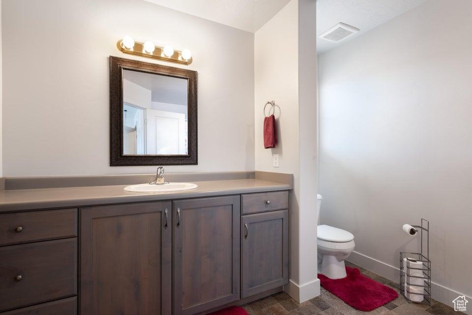 Bathroom featuring tile flooring, toilet, and vanity