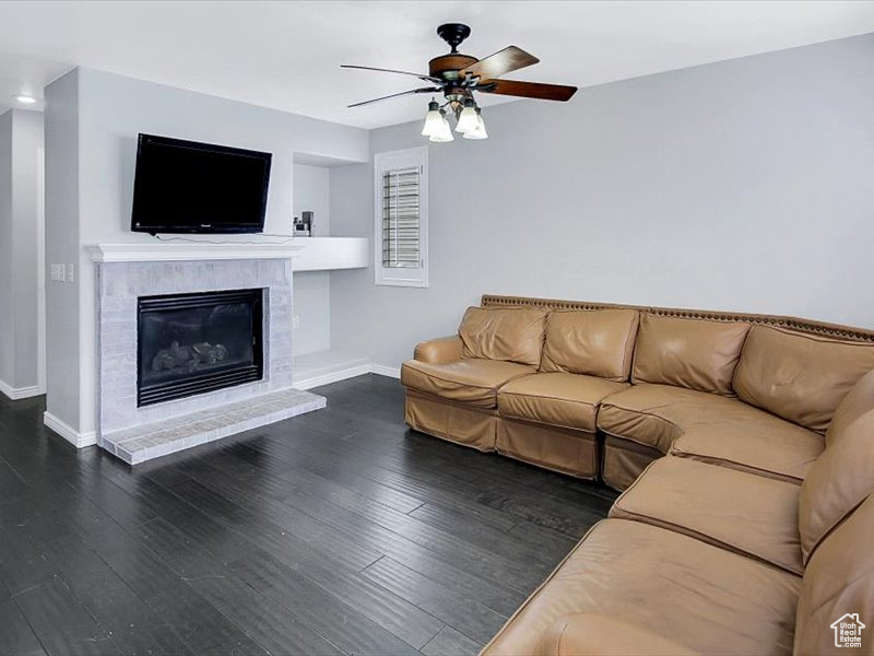 Unfurnished living room featuring dark hardwood / wood-style flooring and ceiling fan