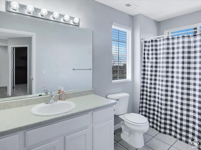 Bathroom featuring oversized vanity, tile flooring, and toilet