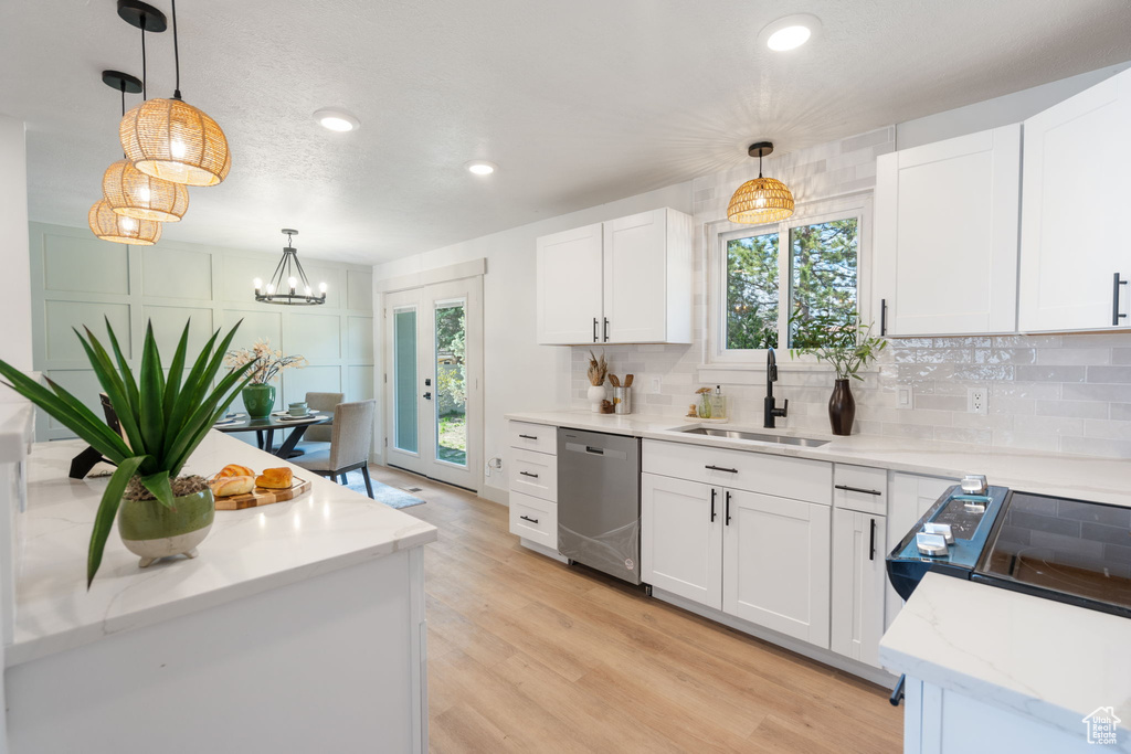 Kitchen with stainless steel dishwasher, pendant lighting, and white cabinetry