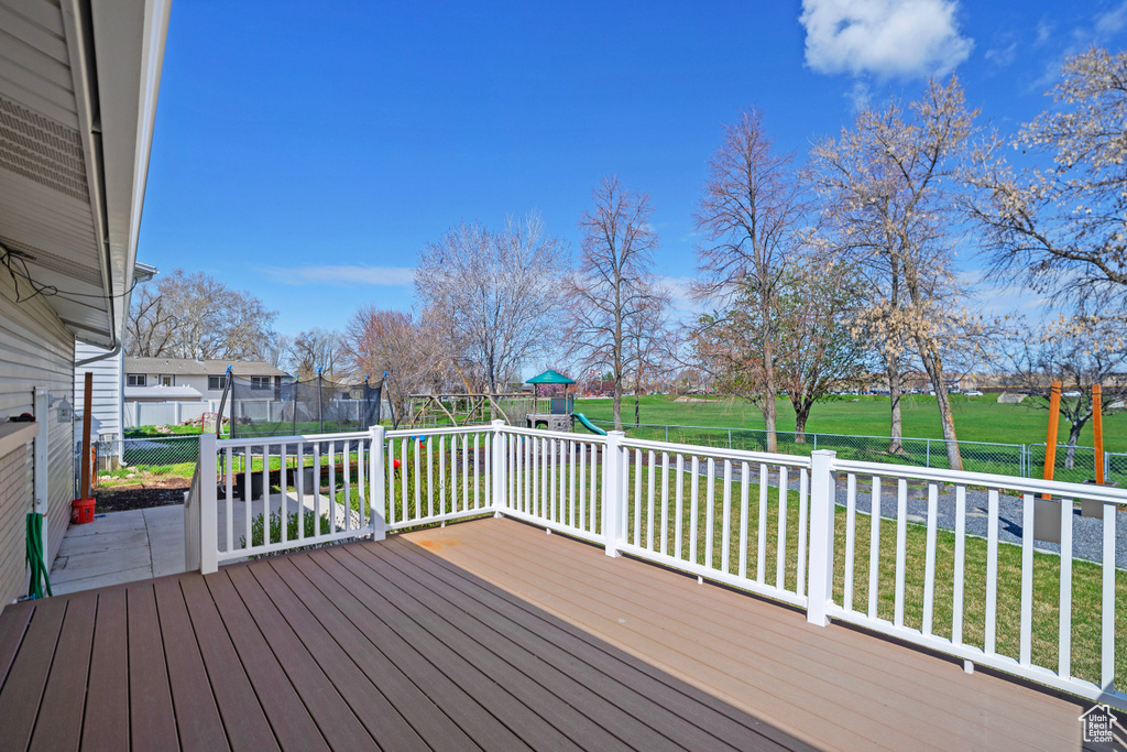 Wooden deck with a playground and a lawn