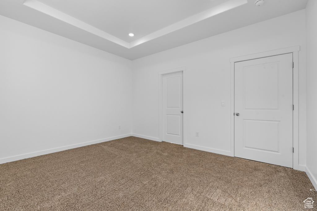 Carpeted empty room with a raised ceiling