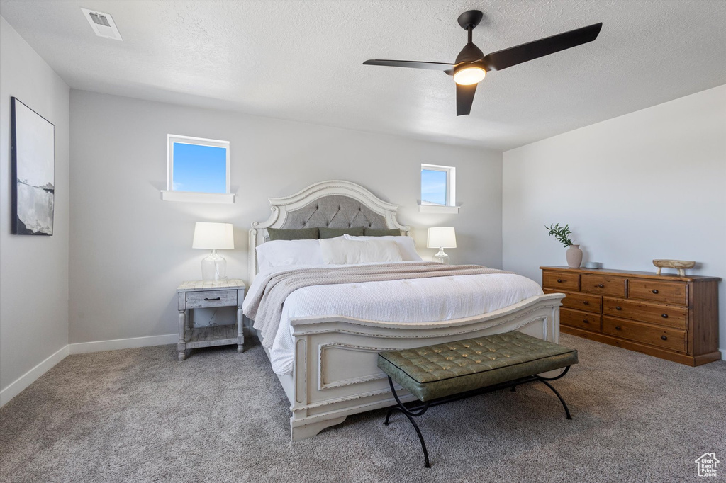Bedroom featuring ceiling fan, a textured ceiling, and carpet