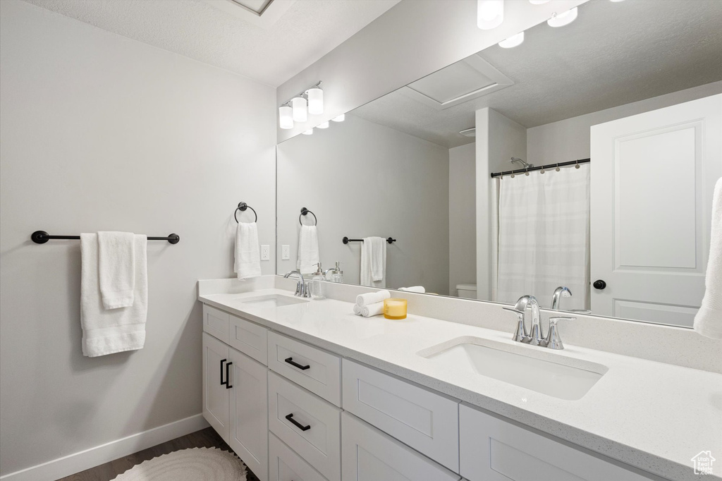 Bathroom with oversized vanity, double sink, and toilet