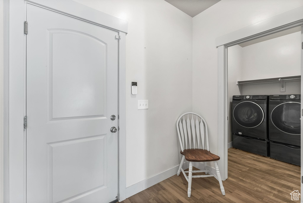 Interior space featuring washing machine and clothes dryer and dark wood-type flooring