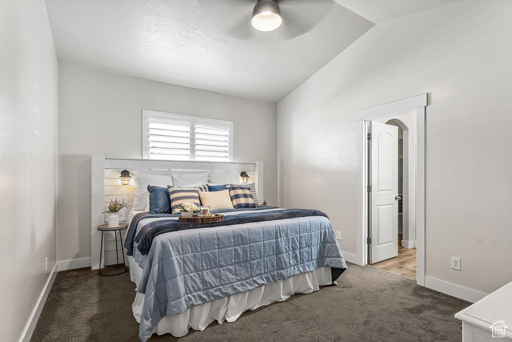 Bedroom with ceiling fan, carpet flooring, and vaulted ceiling