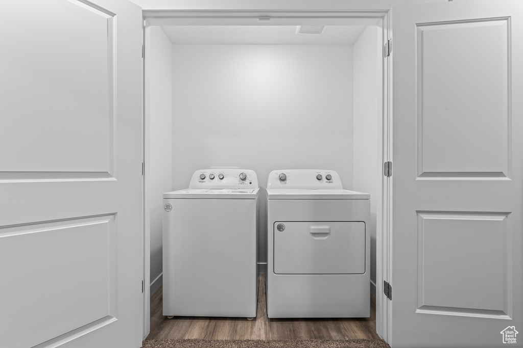Laundry area featuring independent washer and dryer and dark wood-type flooring