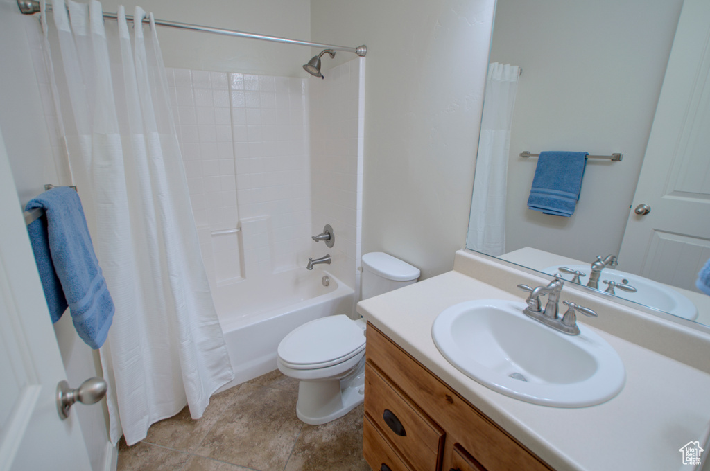 Full bathroom featuring tile flooring, shower / bath combo with shower curtain, toilet, and vanity