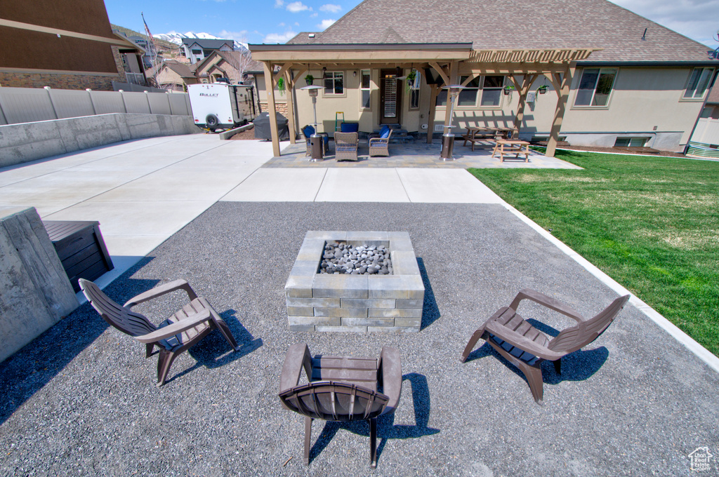 View of terrace with an outdoor fire pit and a pergola