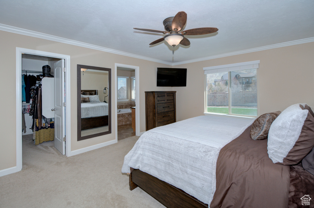 Bedroom featuring ceiling fan, ornamental molding, light colored carpet, and ensuite bathroom
