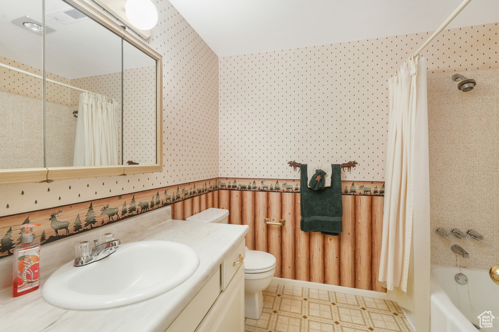 Full bathroom with tile flooring, toilet, oversized vanity, and shower / tub combo