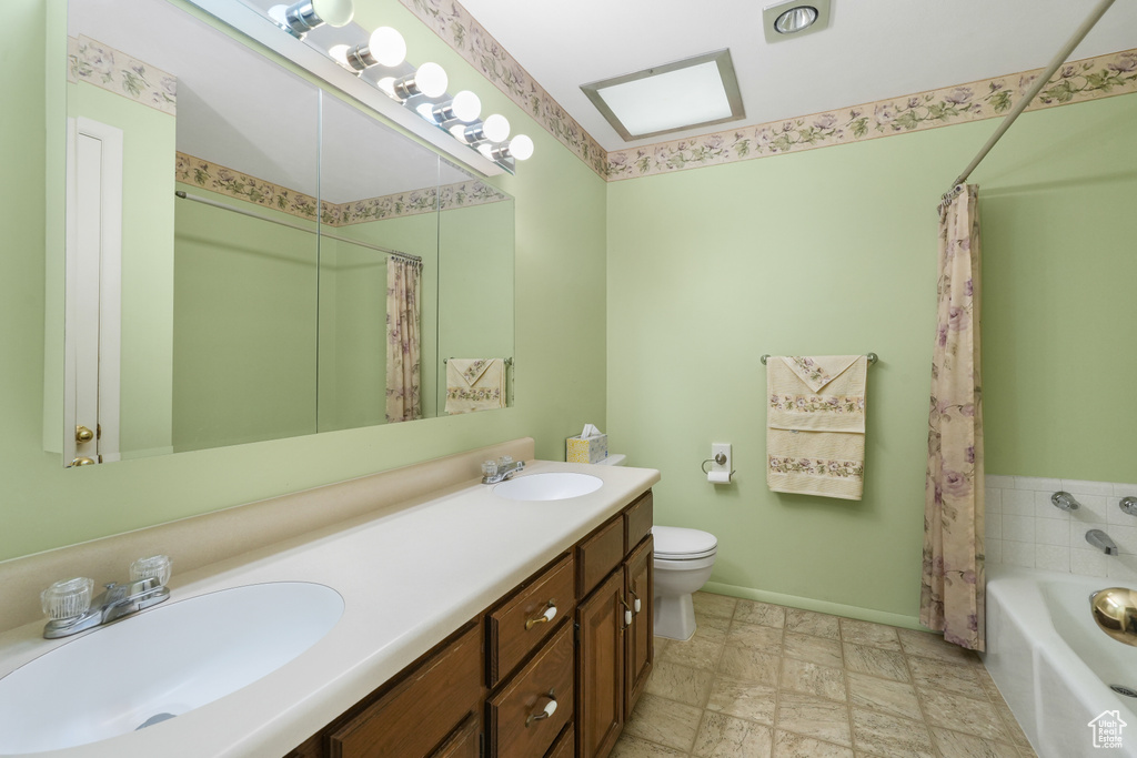 Full bathroom featuring dual sinks, shower / tub combo, tile flooring, toilet, and large vanity
