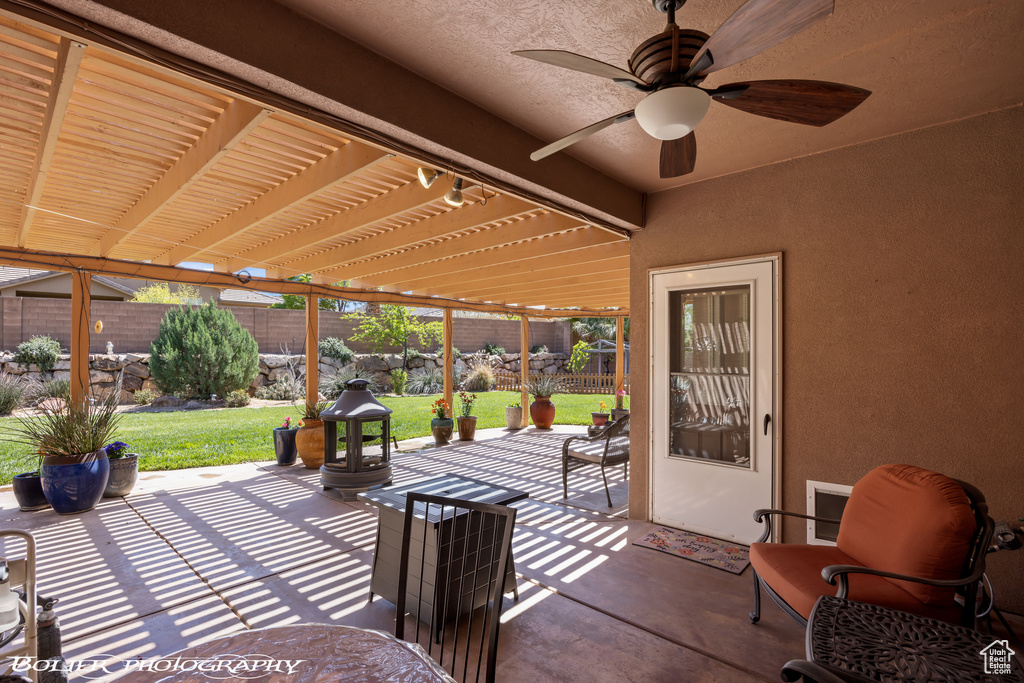 View of terrace with ceiling fan and a pergola