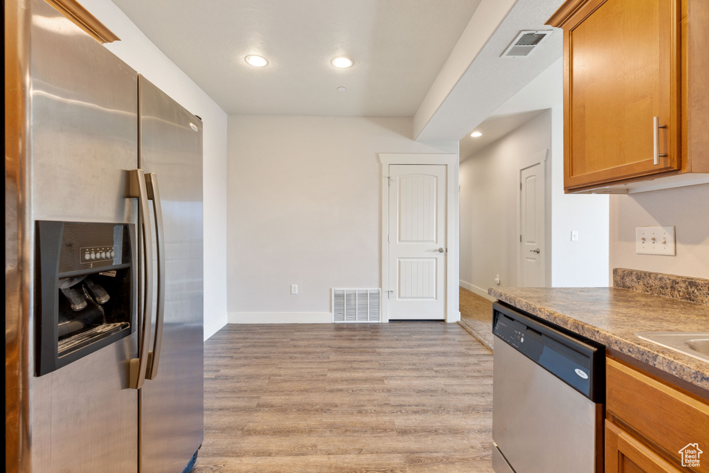 Kitchen featuring appliances with stainless steel finishes and light hardwood / wood-style flooring
