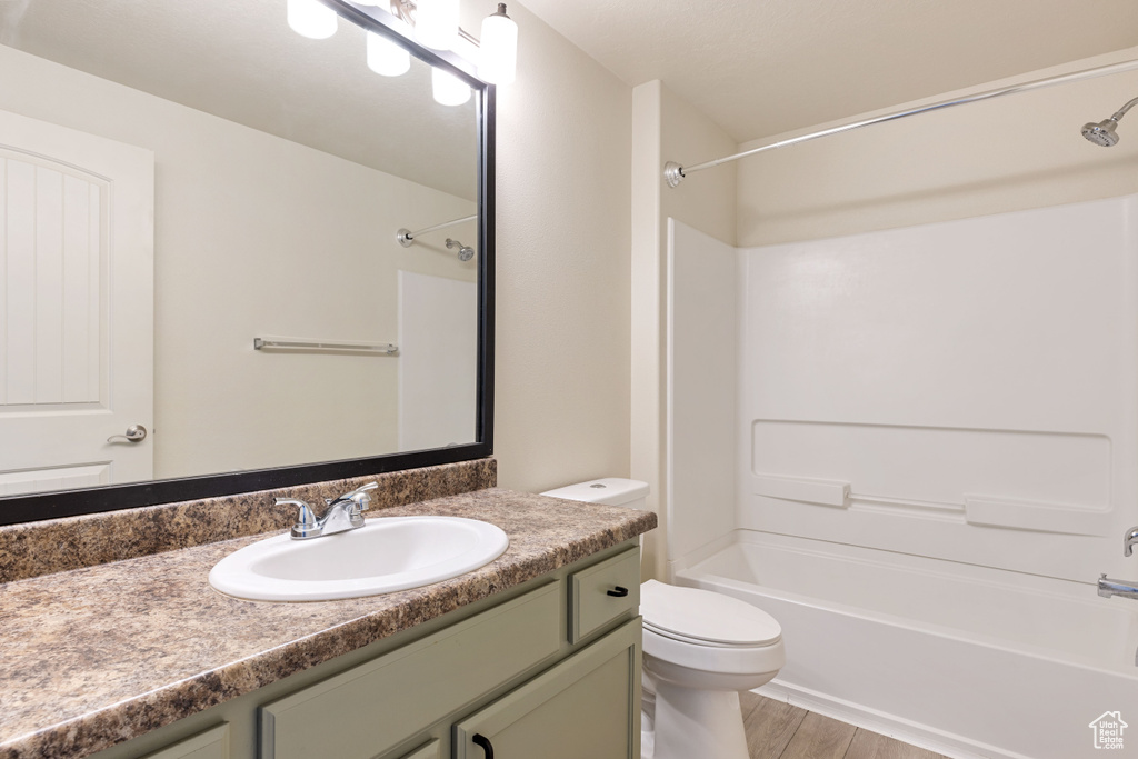 Full bathroom featuring shower / washtub combination, toilet, hardwood / wood-style floors, and vanity