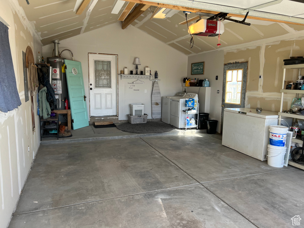 Garage featuring washer and clothes dryer, water heater, and a garage door opener