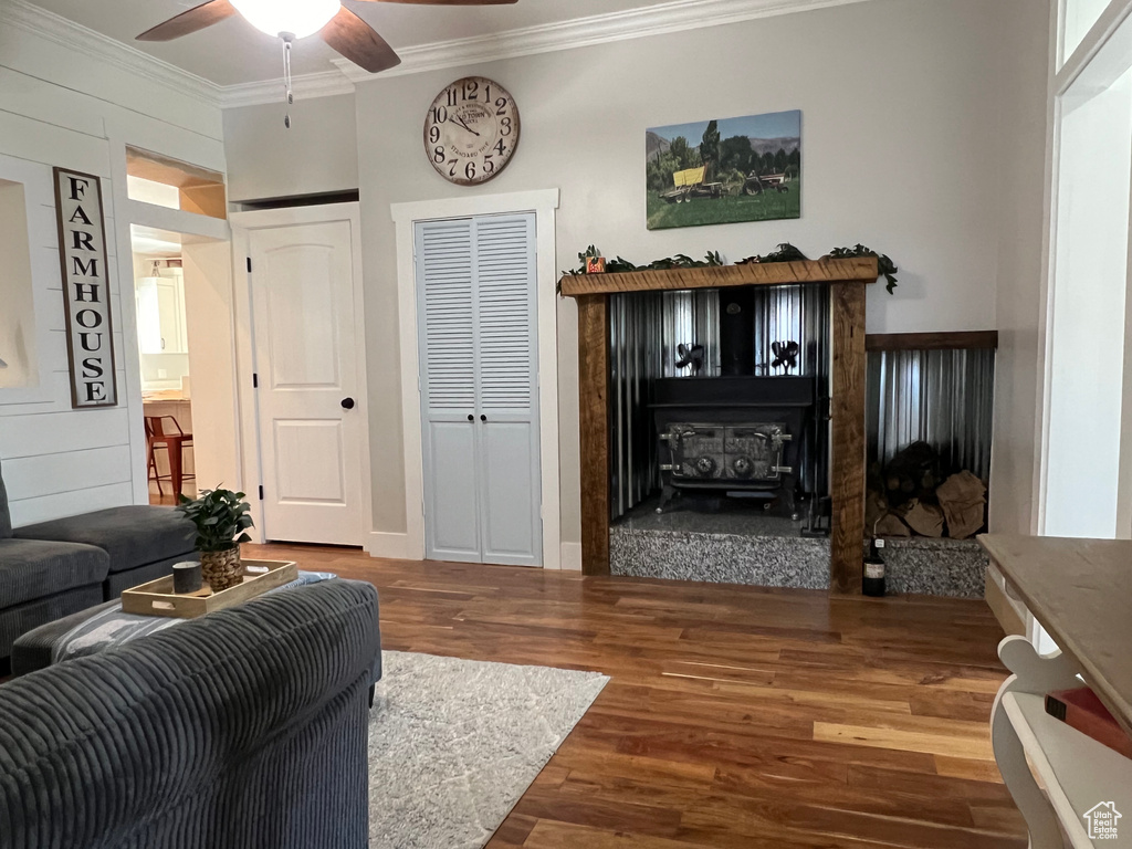 Living room featuring ceiling fan, crown molding, and dark hardwood / wood-style floors