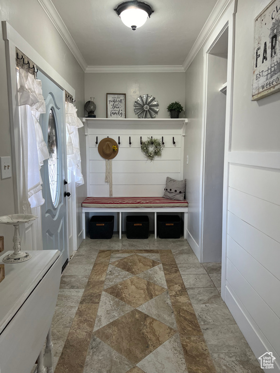 Mudroom with crown molding and light tile flooring