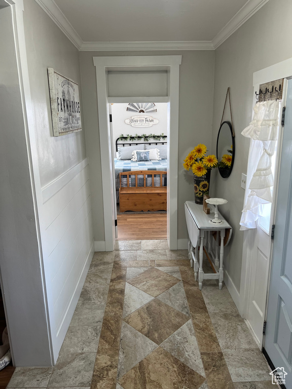 Hallway featuring crown molding and light tile floors