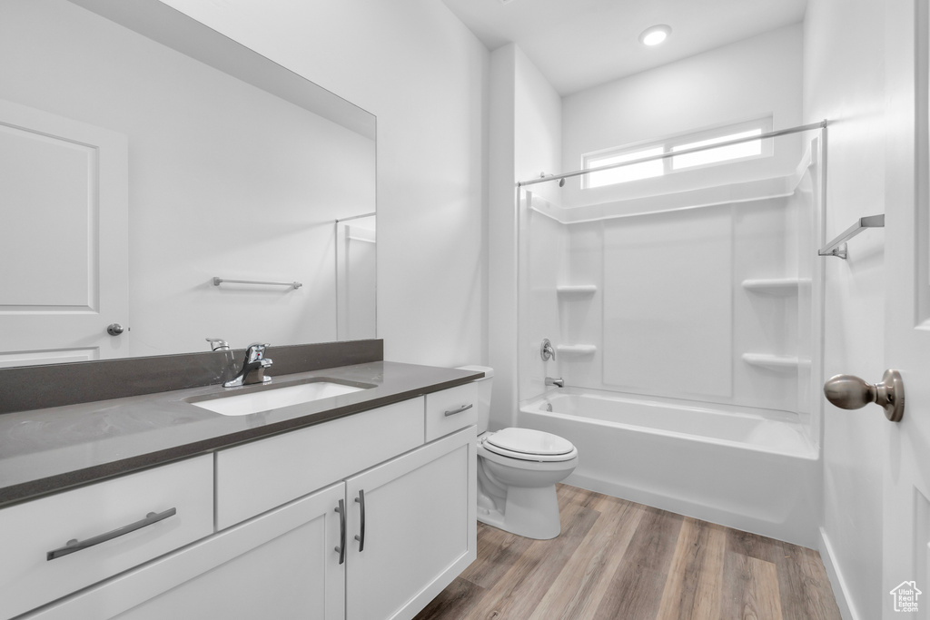 Full bathroom featuring bathtub / shower combination, toilet, wood-type flooring, and vanity