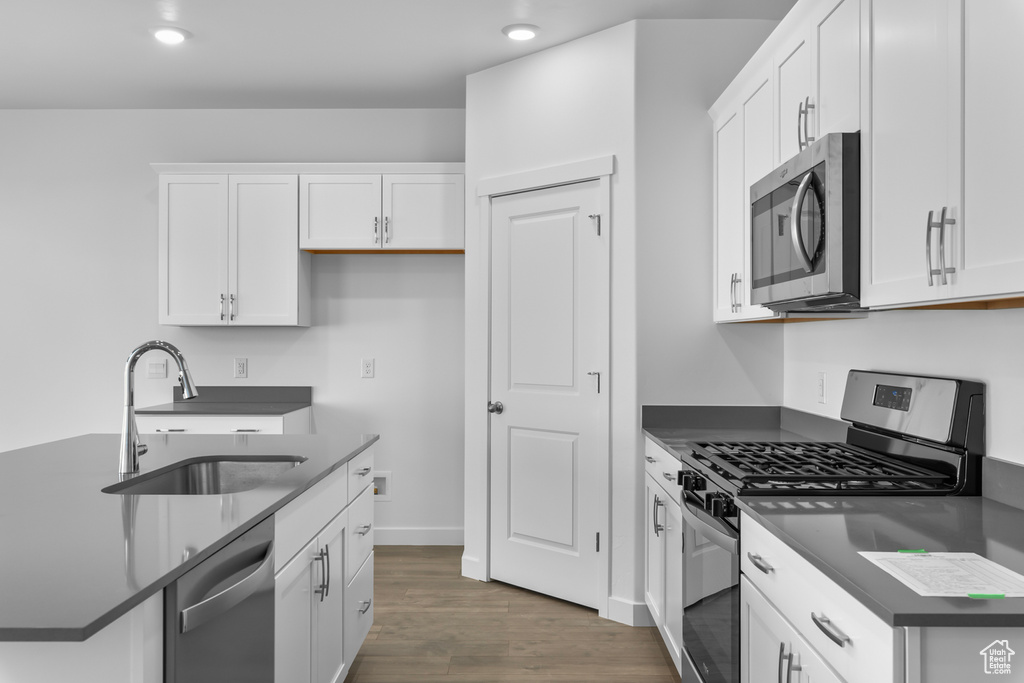 Kitchen featuring white cabinetry, dark wood-type flooring, appliances with stainless steel finishes, and sink
