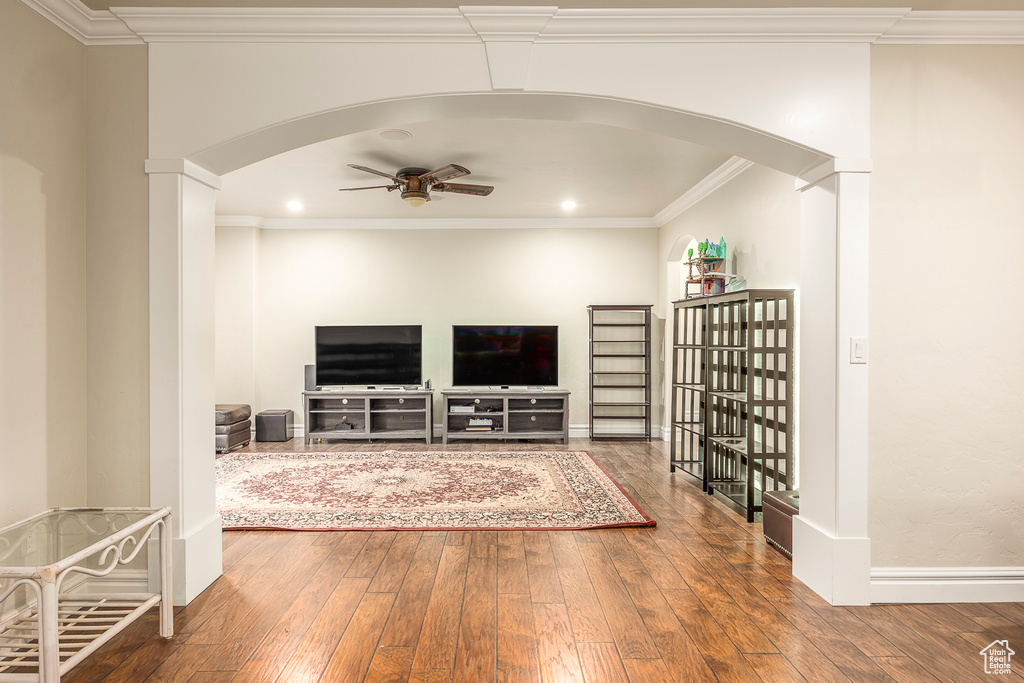 Living room featuring ceiling fan, ornamental molding, and dark hardwood / wood-style floors