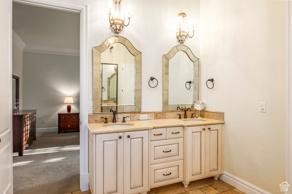 Bathroom with crown molding, tile floors, a chandelier, and double vanity