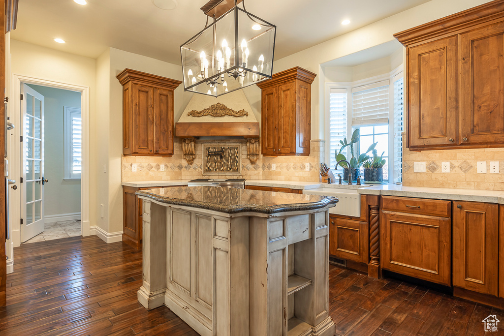 Kitchen featuring dark hardwood / wood-style flooring, a wealth of natural light, a chandelier, and tasteful backsplash