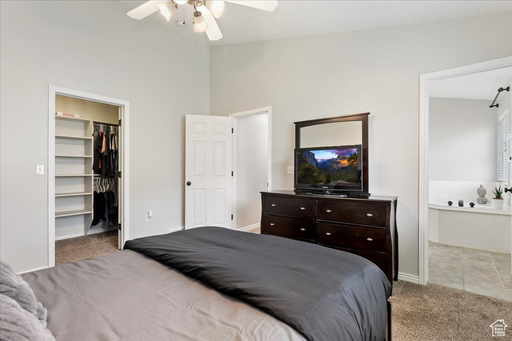 Bedroom featuring ceiling fan, light tile flooring, a closet, vaulted ceiling, and a walk in closet