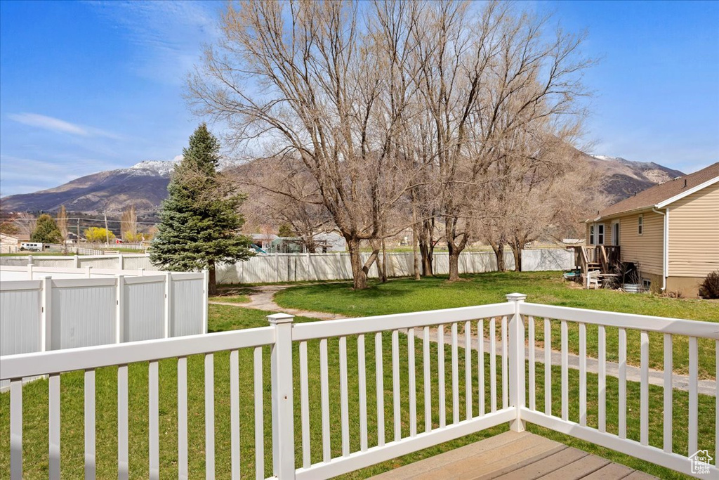 Wooden deck featuring a yard and a mountain view